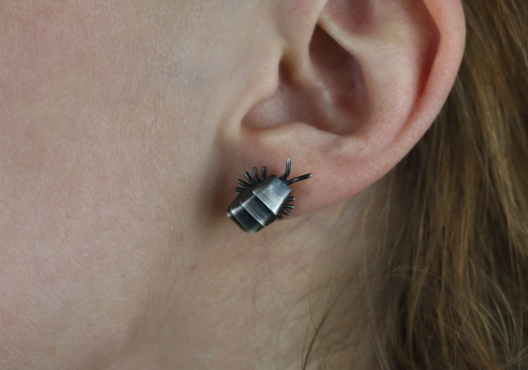 Srebrny kolczyk chrząszcz na uchu